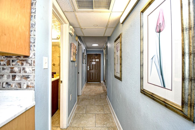 hallway with a paneled ceiling