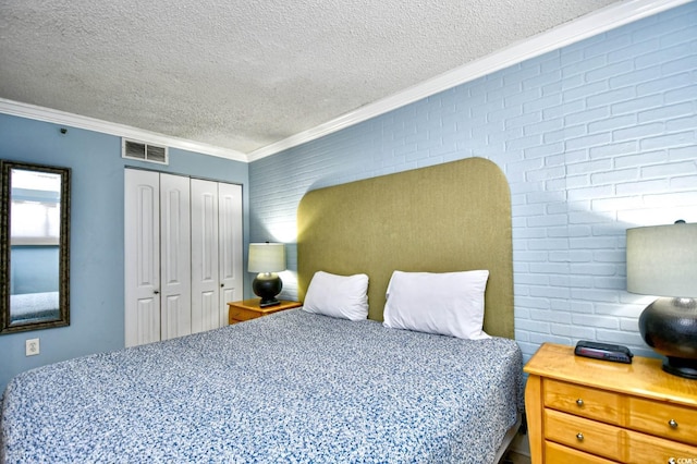 bedroom with a textured ceiling, a closet, crown molding, and brick wall