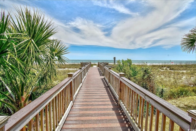 surrounding community with a water view and a beach view