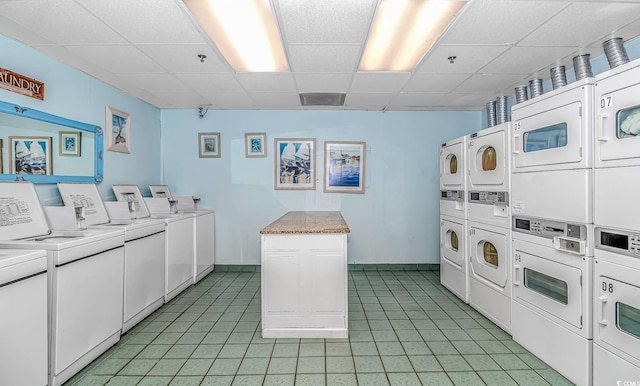 washroom featuring washer and clothes dryer, light tile patterned flooring, and stacked washing maching and dryer