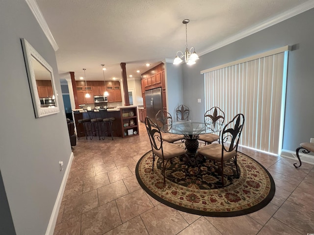 dining area with ornamental molding, a textured ceiling, and an inviting chandelier