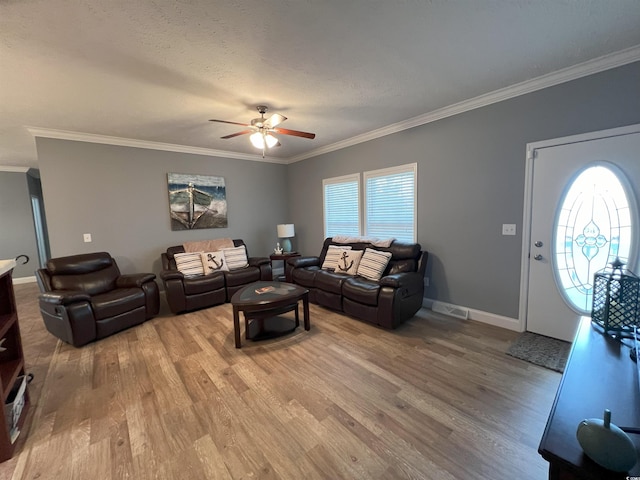 living room with a textured ceiling, hardwood / wood-style flooring, ceiling fan, and crown molding