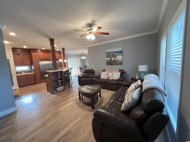 living room with ornamental molding, a textured ceiling, ceiling fan, and light hardwood / wood-style flooring