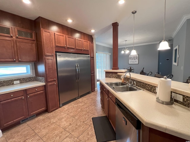 kitchen featuring pendant lighting, appliances with stainless steel finishes, sink, and ornamental molding