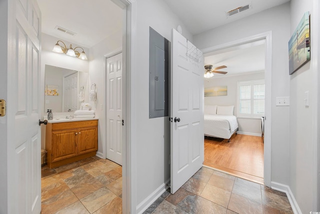 bathroom featuring wood-type flooring, vanity, electric panel, and ceiling fan