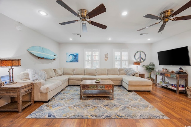 living room featuring hardwood / wood-style floors and ceiling fan