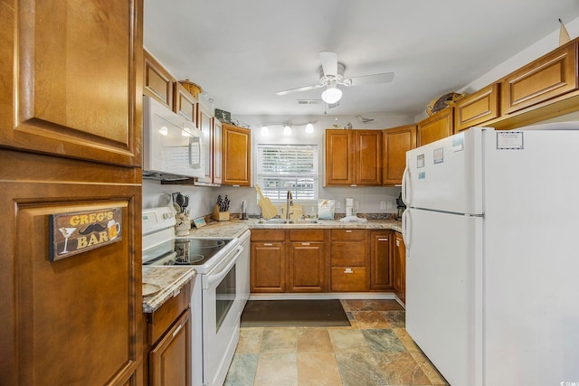 kitchen featuring light stone countertops, white appliances, ceiling fan, and sink