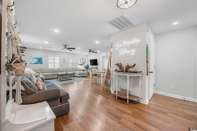 living room featuring ceiling fan and hardwood / wood-style flooring