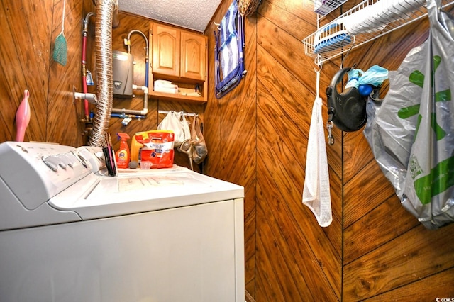 laundry room with washer and dryer, wooden walls, cabinets, and a textured ceiling