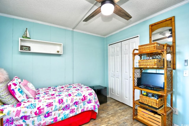 bedroom with ceiling fan, crown molding, a textured ceiling, a closet, and hardwood / wood-style flooring