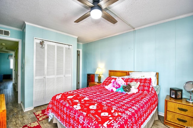 bedroom featuring ceiling fan, crown molding, a textured ceiling, a closet, and hardwood / wood-style flooring