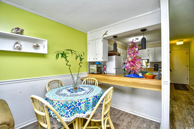 4305 S Ocean Blvd Unit 205, North Myrtle Beach, SC 29582 - dining area with a textured ceiling, wood finished floors, and ornamental molding