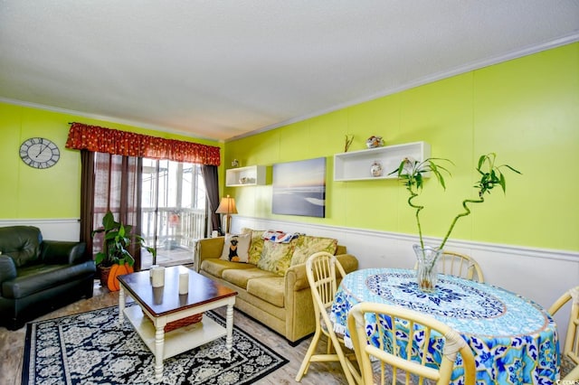 4305 S Ocean Blvd Unit 205, North Myrtle Beach, SC 29582 - living area featuring ornamental molding, a decorative wall, and a wainscoted wall