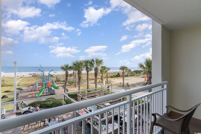 balcony featuring a view of the beach and a water view