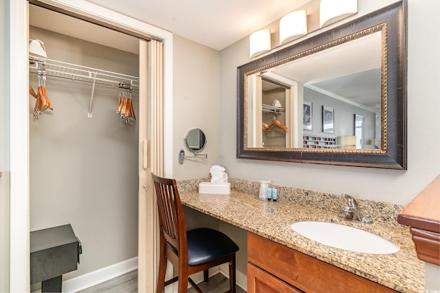 bathroom with hardwood / wood-style floors, vanity, and ornamental molding