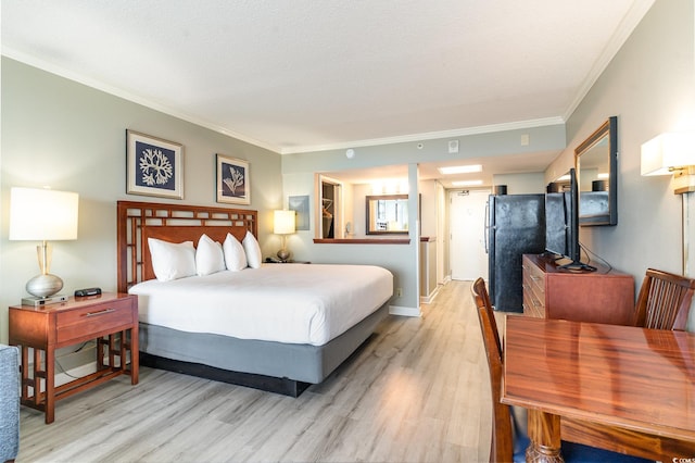 bedroom with a textured ceiling, light hardwood / wood-style flooring, and crown molding