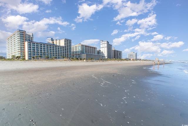 view of building exterior featuring a water view and a view of the beach