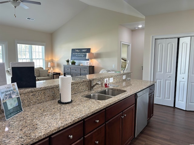 kitchen with sink, light stone counters, dark hardwood / wood-style floors, stainless steel dishwasher, and lofted ceiling