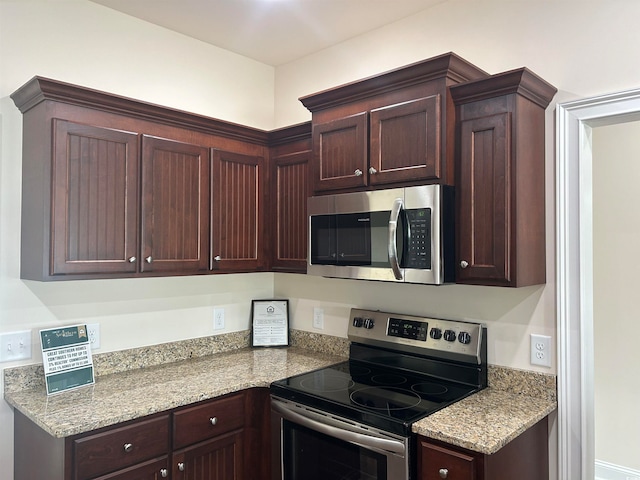 kitchen with light stone countertops and stainless steel appliances