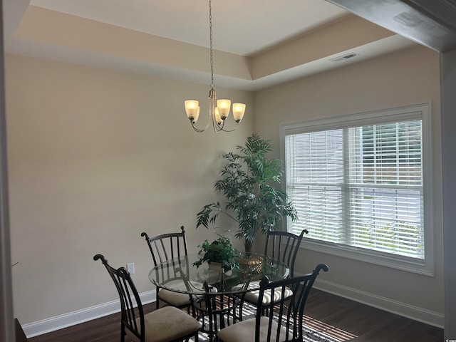 dining space featuring dark hardwood / wood-style floors, plenty of natural light, and a tray ceiling