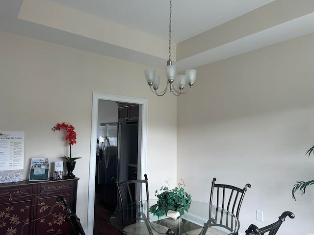 dining area with dark hardwood / wood-style flooring and a notable chandelier