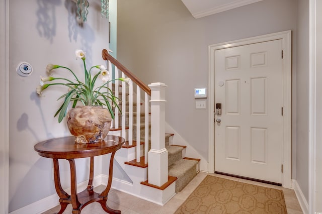 foyer entrance featuring light tile patterned floors and crown molding