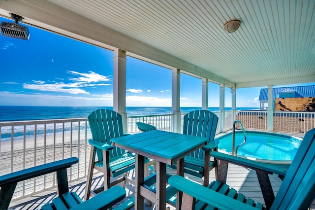 sunroom featuring a water view and a view of the beach