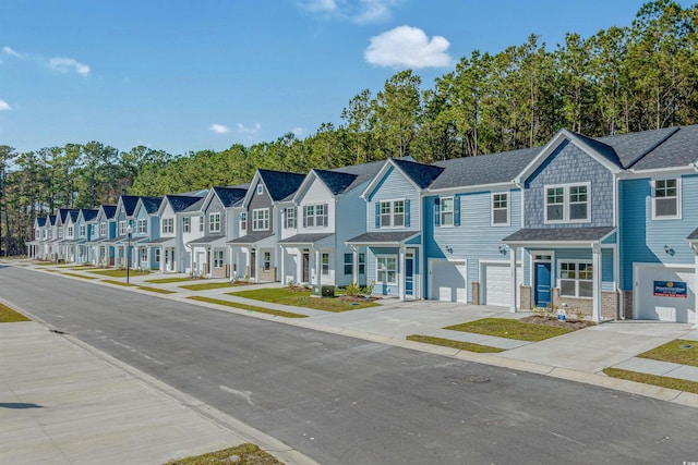 townhome / multi-family property featuring an attached garage, driveway, and a residential view