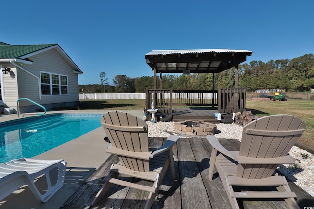 view of pool featuring a gazebo, a deck, and an outdoor fire pit