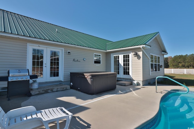 exterior space featuring a pool with hot tub, a patio, and french doors