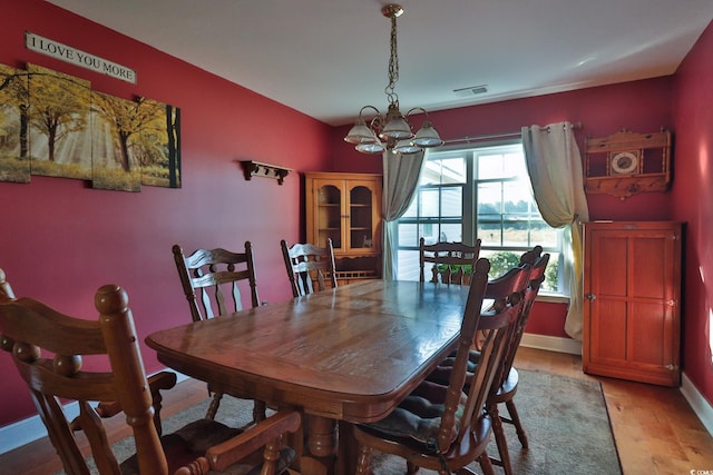 dining space featuring light hardwood / wood-style flooring and a chandelier