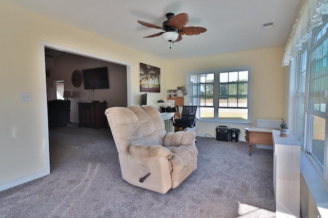 carpeted living room with ceiling fan