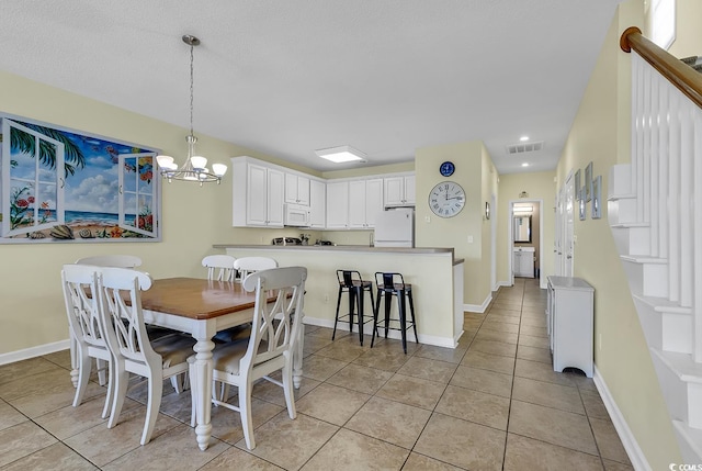 dining room featuring light tile patterned flooring and a chandelier