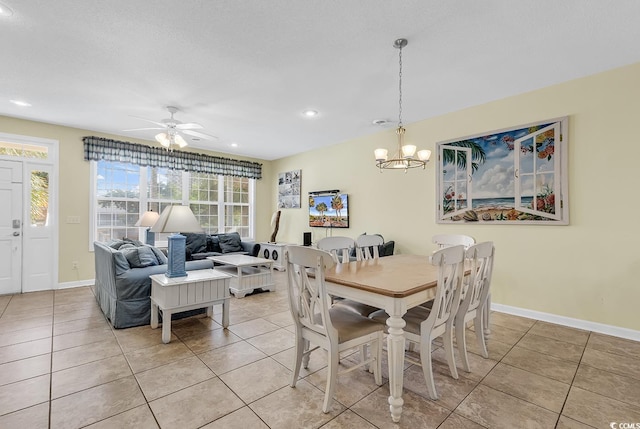 tiled dining area featuring ceiling fan with notable chandelier