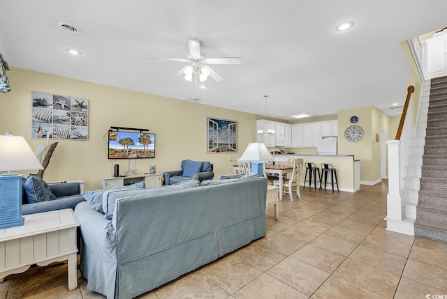 living room featuring ceiling fan with notable chandelier and light tile patterned floors