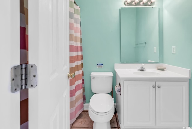 bathroom featuring tile patterned flooring, vanity, and toilet