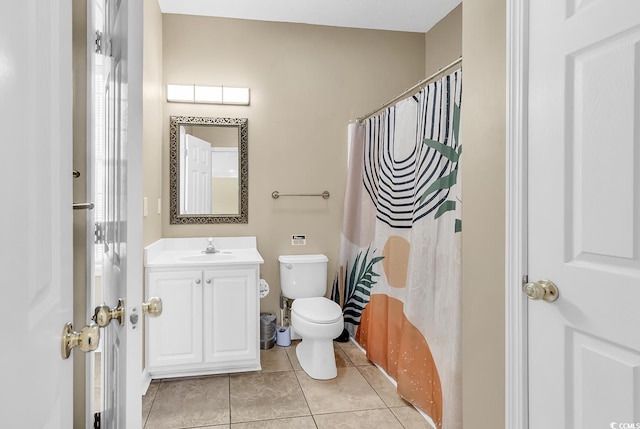 bathroom with toilet, vanity, tile patterned floors, and walk in shower