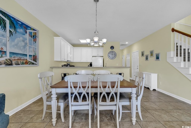 tiled dining area featuring an inviting chandelier