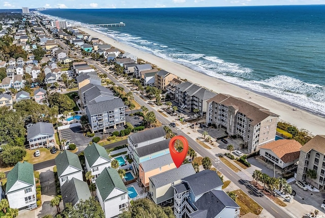 birds eye view of property with a water view and a beach view