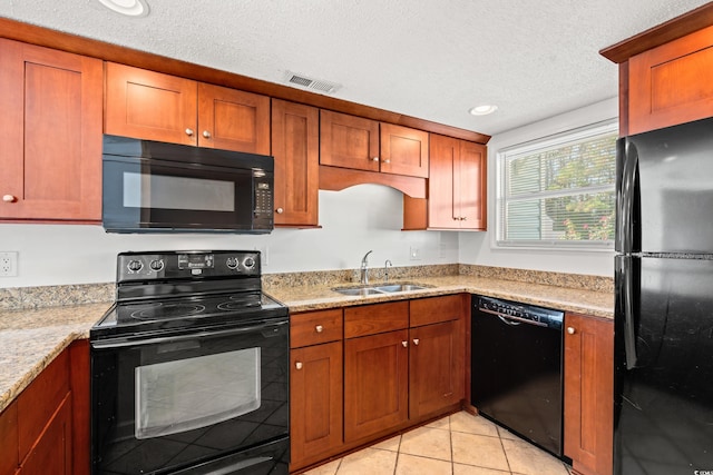 kitchen with a textured ceiling, black appliances, sink, and light tile patterned flooring