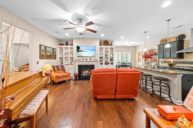 living room with dark hardwood / wood-style flooring and ceiling fan