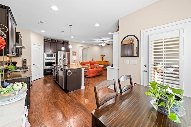 dining space with dark wood-type flooring, ceiling fan, and sink