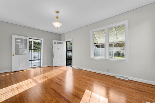 unfurnished room with baseboards, visible vents, and light wood-style floors