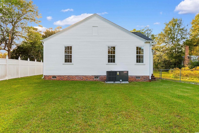 view of side of property featuring central AC, a yard, crawl space, and a fenced backyard