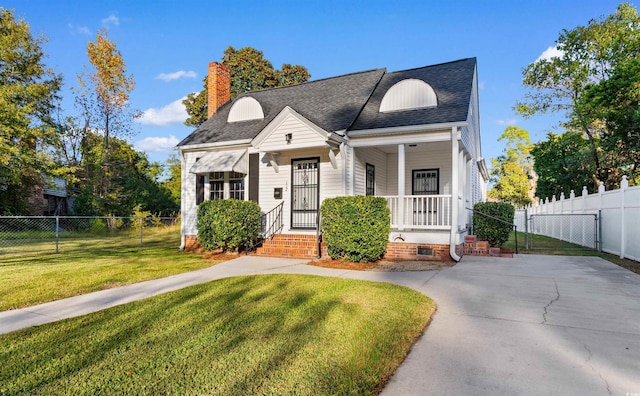 view of front of home with a porch, a shingled roof, fence, a front lawn, and a chimney