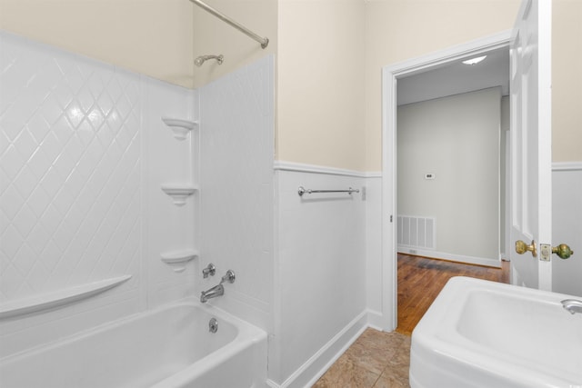 full bathroom with tile patterned flooring, wainscoting, visible vents, and shower / tub combination