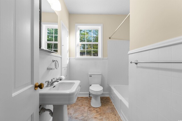 bathroom with bathing tub / shower combination and toilet