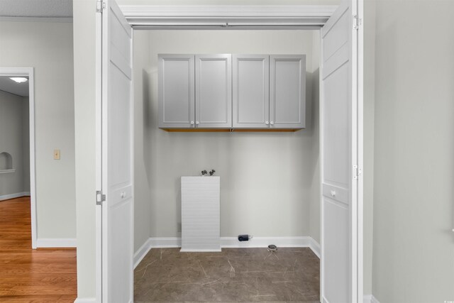 washroom featuring cabinet space, dark wood finished floors, and baseboards