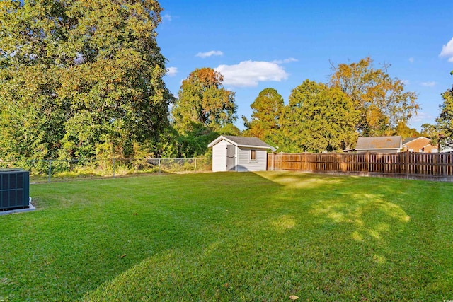 view of yard featuring an outbuilding, a fenced backyard, cooling unit, and a shed