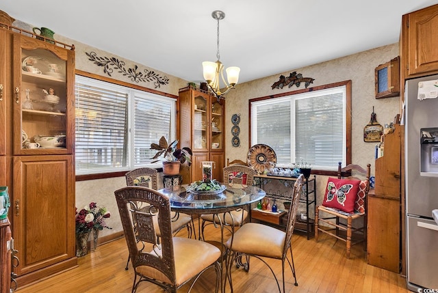 dining space featuring light hardwood / wood-style floors and an inviting chandelier